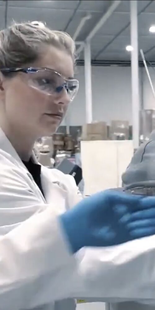 lab technician observing beaker with hemp product